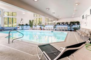 a large swimming pool in a large room with chairs at Sunrise Mountain Village in Killington
