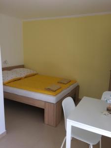 Habitación pequeña con cama y mesa en Zseli Apartmanház, en Siófok