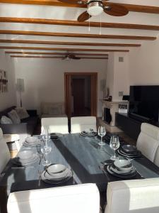 Casa Luna في La Drova: غرفة معيشة مع طاولة مع أطباق وكؤوس للنبيذ
