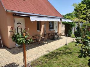 a patio of a house with chairs and tables at Zseli Apartmanház in Siófok