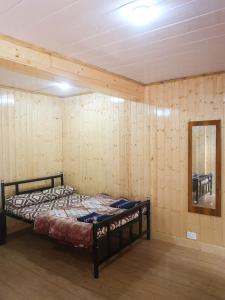 a bedroom with a bed in a wooden wall at Homestay Darjeeling in Darjeeling