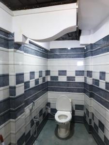 a bathroom with a toilet with blue and white tiled walls at Homestay Darjeeling in Darjeeling