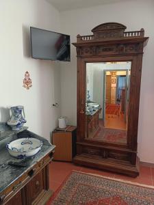 a bathroom with a large wooden cabinet with a mirror at La Maison Rouge in Crespellano