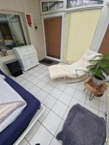 um quarto com uma cama e uma cadeira num piso de azulejo em Waldoase im Herzen des Teutoburger Waldes - Handwerker auf Anfrage em Bad Iburg