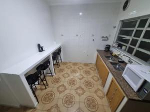 una cocina con encimera y algunos taburetes en ella en Villa Fátima Hostel GRU, en Guarulhos