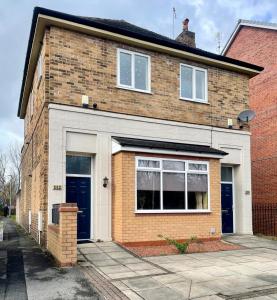 a brick house with a blue door on a street at Simple Compact House ! in Wythenshawe