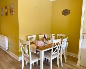 a dining room with a wooden table and chairs at Simple Compact House ! in Wythenshawe