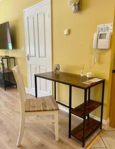 a table and a chair in a room at Simple Compact House ! in Wythenshawe