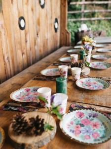 uma longa mesa de madeira com pratos e copos sobre ela em Moonlight Chalet Brasov em Codlea