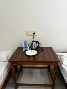 drewniany stół z czajnikiem do herbaty obok łóżka w obiekcie Temple View Home Stay w mieście Tiruvannamalai