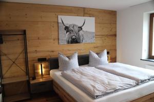 1 dormitorio con 1 cama con una foto de un toro en Neue Ferienwohnung in Altendorf mit Garten en Sebnitz