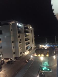 Blick auf eine Stadt in der Nacht mit Gebäuden in der Unterkunft Apartamento aconchegante vista mar e piscina em cond de Arraial do Cabo in Arraial do Cabo