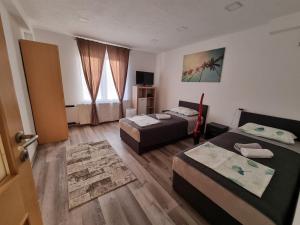 a hotel room with two beds and a living room at Apartments Jasko in Ig