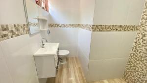 La salle de bains blanche est pourvue de toilettes et d'un lavabo. dans l'établissement Reserve Temporada - Chácara 01, à Olímpia