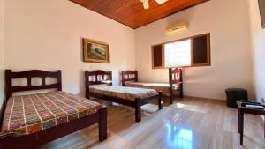 Cette chambre comprend 2 lits et une fenêtre. dans l'établissement Reserve Temporada - Chácara 01, à Olímpia