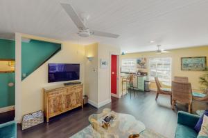 sala de estar con sofá y TV en Old Town Garden Villas - Andros Suite, en Key West