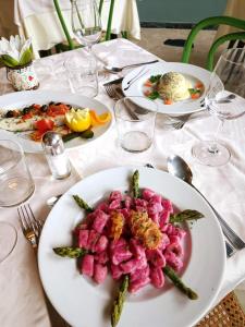 ein weißer Tisch mit Teller mit Lebensmitteln drauf in der Unterkunft Hotel Ramoverde in Borgomanero