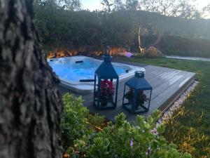 uma banheira de hidromassagem com duas luzes em um deck de madeira em B&B Casrienn em Mattinata