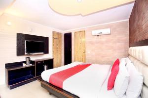 een slaapkamer met een groot bed en een televisie bij Hotel Continental Inn in Chandīgarh
