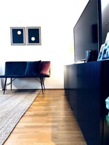 uma sala de estar com um banco e uma televisão em Lovely 2 bedroom apartment with a large own patio em Garðabær