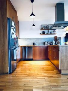 cocina con suelo de madera y electrodomésticos de acero inoxidable en Lovely 2 bedroom apartment with a large own patio, en Garðabær