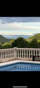 a white fence around a swimming pool with a view of the ocean at Casa Luna in La Drova