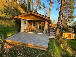 a tiny house with a deck in the woods at Ferienhaus in Västerrå mit Garten und Terrasse 