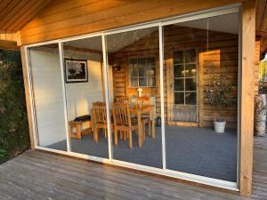 una cortina en el porche de una cabaña con mesa en Ferienhaus in Västerrå mit Garten und Terrasse, 