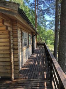 a cabin with a wooden deck in the woods at Ferienhaus in Västerrå mit Garten und Terrasse 