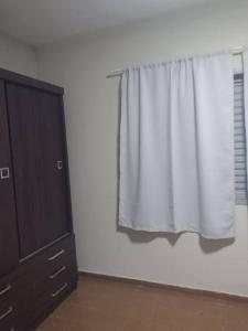 uma janela com uma cortina branca ao lado de uma cómoda em Casa centro Itupeva hopii wet em Itupeva