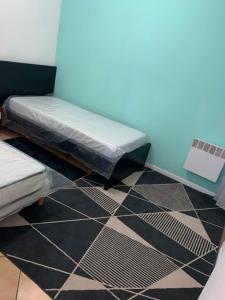 two beds in a room with black and white tiles at La Pause in Lormont