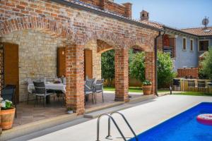 un patio extérieur avec une table et une piscine dans l'établissement Villa Amani, à Butkovići