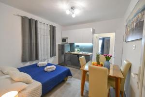 uma sala de estar com uma cama azul e uma mesa em Ferienwohnung in Gradac em Gradac
