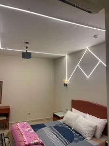 um quarto com uma cama e um projector no tecto em porto sokhna Pyramids Apartment Familis em Ain Sokhna