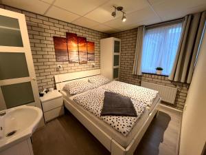 a small bedroom with a bed and a sink at Ferienhaus CARPE DIEM Schoneveld - Breskens - Urlaub mit Hund in Breskens