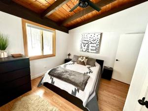 een slaapkamer met een bed en een houten plafond bij Iron Gate Chalet - 5 Minutes to Smugglers Notch! in Cambridge