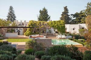 a garden with a swimming pool and a house at Dimora Dei Semplici in Cisternino