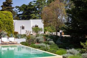 a garden with a pool in front of a white house at Dimora Dei Semplici in Cisternino