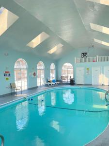 a large swimming pool with blue water in a building at Carriage House Inn in Branson