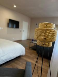 a bedroom with a bed and a lamp in the foreground at Modernes Apartment am Dreiländereck in Alsdorf