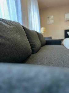 a couch sitting in a living room next to a window at Modernes Apartment am Dreiländereck in Alsdorf