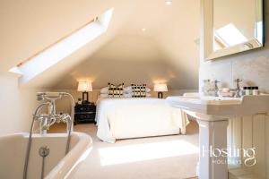 a bedroom with a bed and a tub and a sink at Luxurious 4 Bedroom Villa With Exceptional Views And A Bedroom With A Bath Tub in Twyford