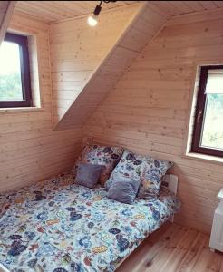 a bed in the corner of a log cabin at Domek pod Dębami Bogaczewo in Bogaczewo