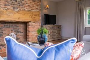 a living room with a blue couch and a fireplace at Luxurious 4 Bedroom Villa With Exceptional Views And A Bedroom With A Bath Tub in Twyford