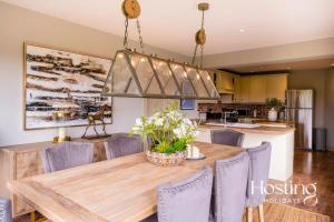 a kitchen and dining room with a wooden table and chairs at Luxurious 4 Bedroom Villa With Exceptional Views And A Bedroom With A Bath Tub in Twyford
