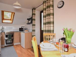 cocina y comedor con mesa de madera y comedor en 2 Bed in Bude NPHON, en Poundstock