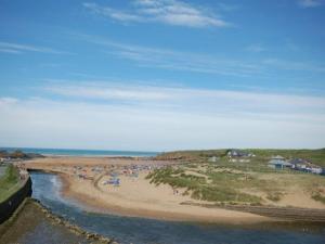 a beach with a bunch of people on the sand at 2 Bed in Bude NPHON in Poundstock