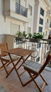 un tavolo in legno e una sedia sul balcone di Amelja's Apartment a Shkodër