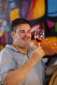 Un uomo sta tenendo un bicchiere di vino di Tempel Wines a Paarl