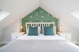 a bedroom with a bed with birds on the wall at Station House in Marlow